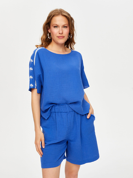 بلوزة موسلين بأكمام قصيرة مزينة بطبعة أشجار النخيل من تصميم فائق سونميز