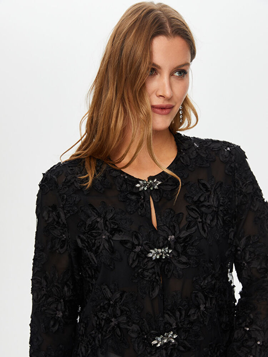 جاكيت سهرة من تصميم فائق سونميز، مزين بتطريزات زهرية وتفاصيل من الترتر.