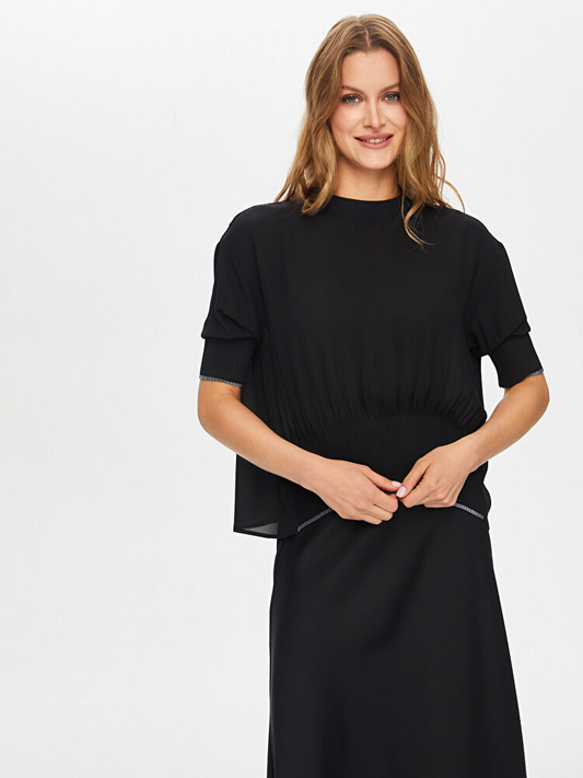 تنورة محبوكة مع بلوزة بتفاصيل ثنيات من تصميم فائق سونميز